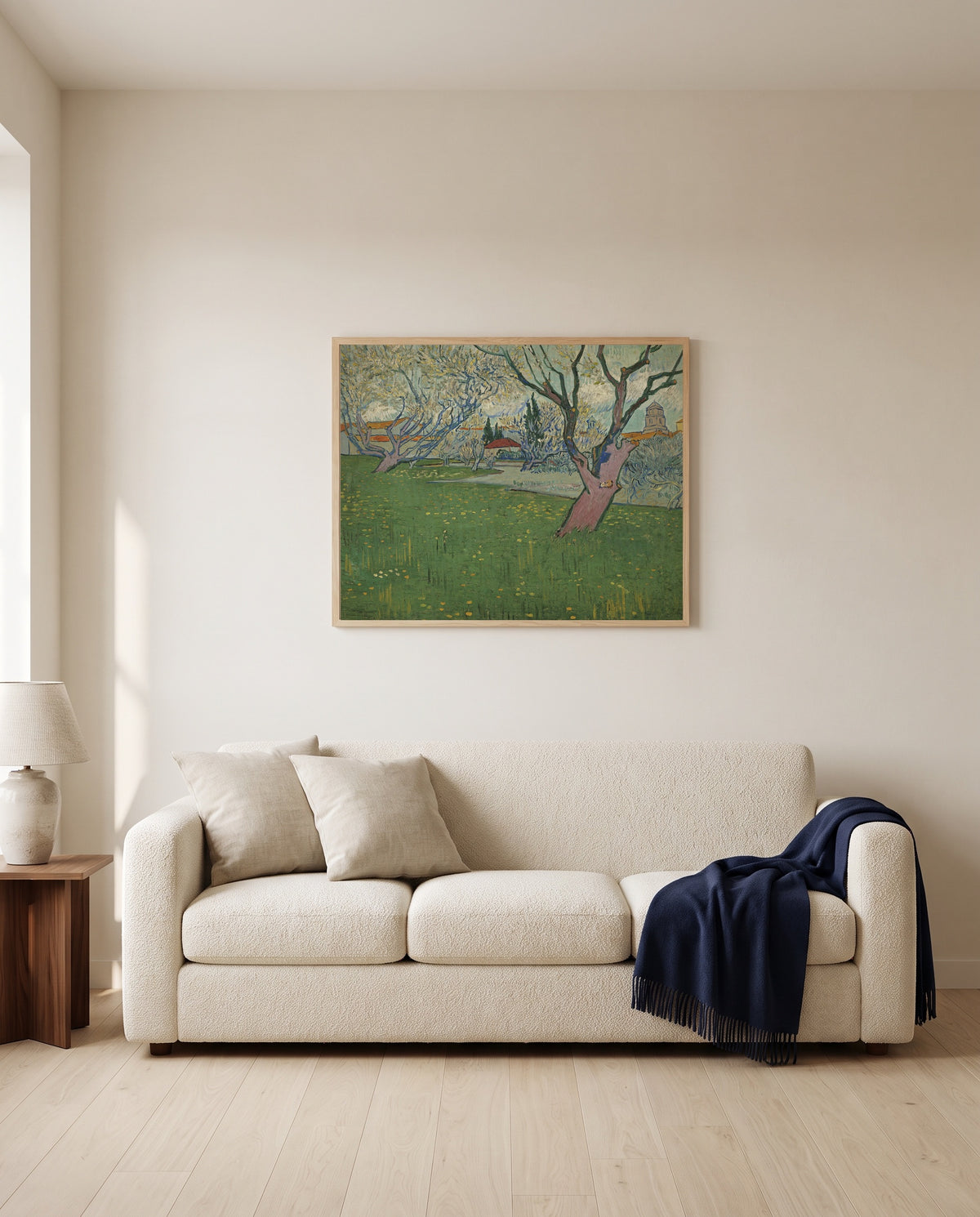 Orchards in Blossom, Arles by Vincent van Gogh framed in natural oak above a cream sofa in a warm living room