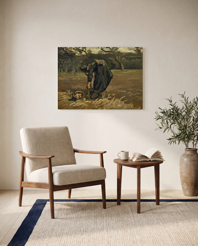 Peasant Woman Digging Up Potatoes by Vincent van Gogh as a stretched canvas above a linen lounge chair in a reading corner