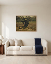 Peasant Woman Digging Up Potatoes by Vincent van Gogh framed in natural oak above a cream sofa in a warm living room