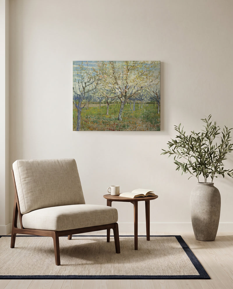 The Pink Orchard by Vincent van Gogh as a stretched canvas above a linen lounge chair in a reading corner