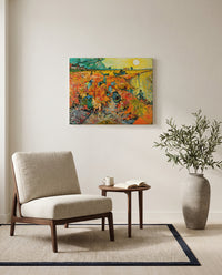 The Red Vineyard by Vincent van Gogh as a stretched canvas above a linen lounge chair in a reading corner