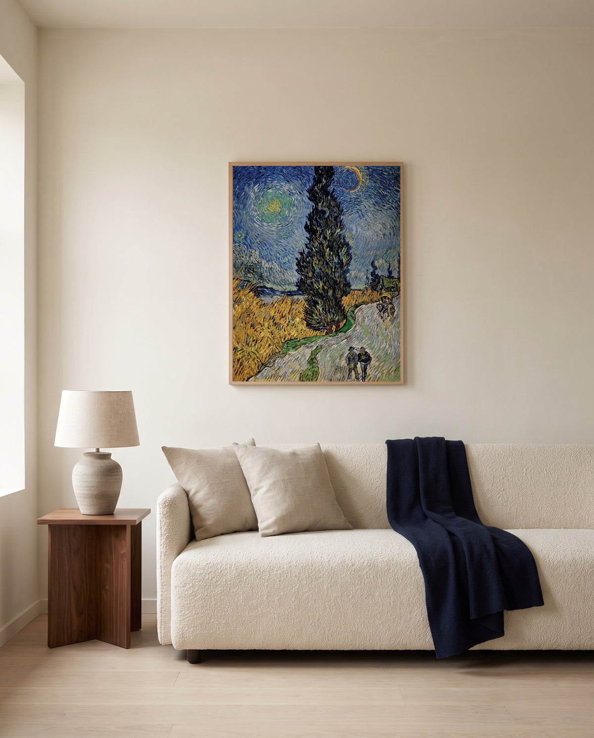 Road with Cypress and Star by Vincent van Gogh framed in natural oak above a cream sofa in a warm living room