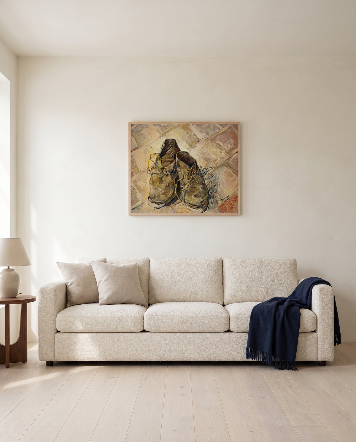 Shoes (1888) by Vincent van Gogh framed in natural oak above a cream sofa in a warm living room