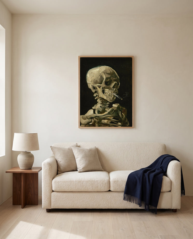 Skull with Burning Cigarette by Vincent van Gogh framed in natural oak above a cream sofa in a warm living room