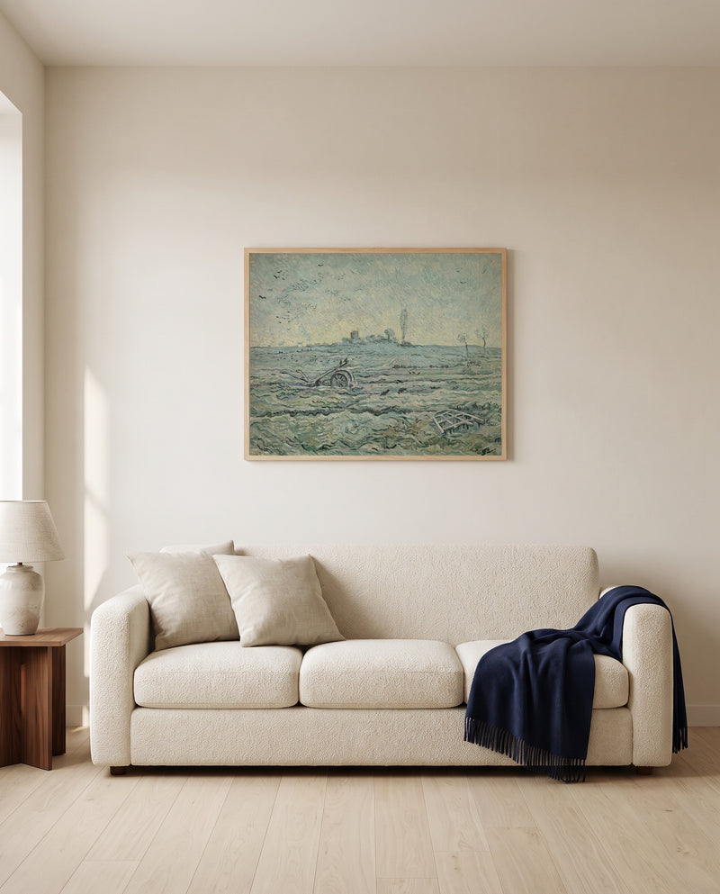 Snow-Covered Field with a Harrow by Vincent van Gogh framed in natural oak above a cream sofa in a warm living room