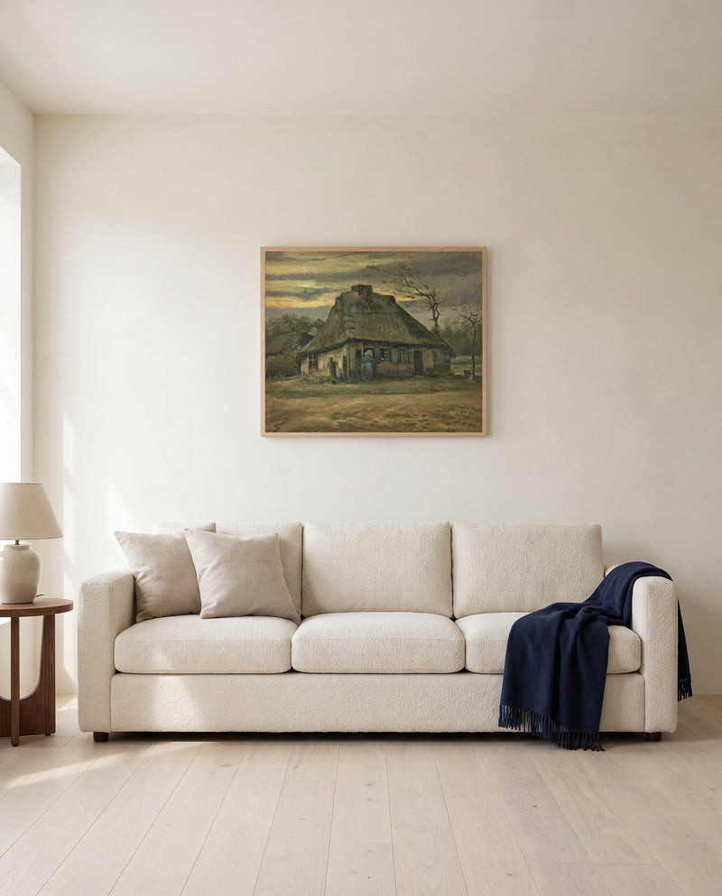 The Cottage by Vincent van Gogh framed in natural oak above a cream sofa in a warm living room