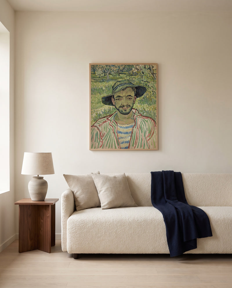 The Gardener by Vincent van Gogh framed in natural oak above a cream sofa in a warm living room