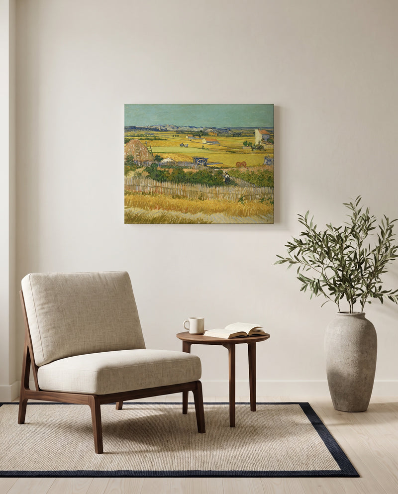 The Harvest by Vincent van Gogh as a stretched canvas above a linen lounge chair in a reading corner