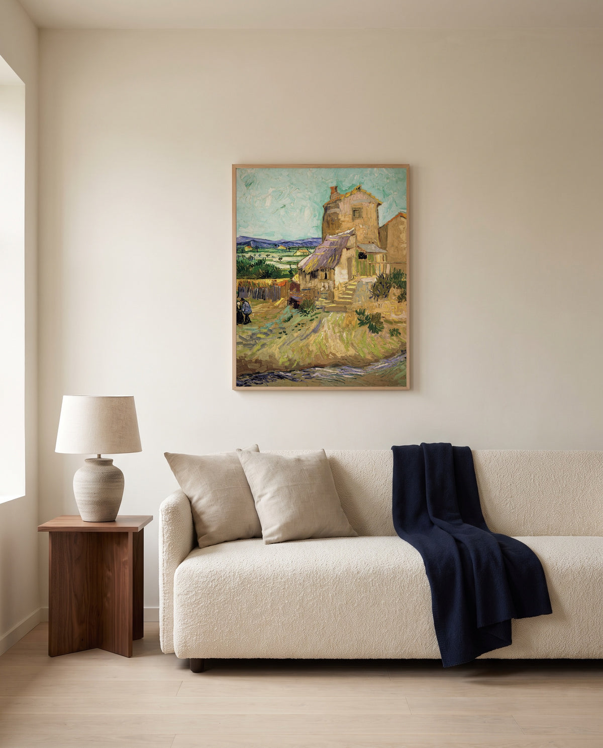 The Old Mill by Vincent van Gogh framed in natural oak above a cream sofa in a warm living room