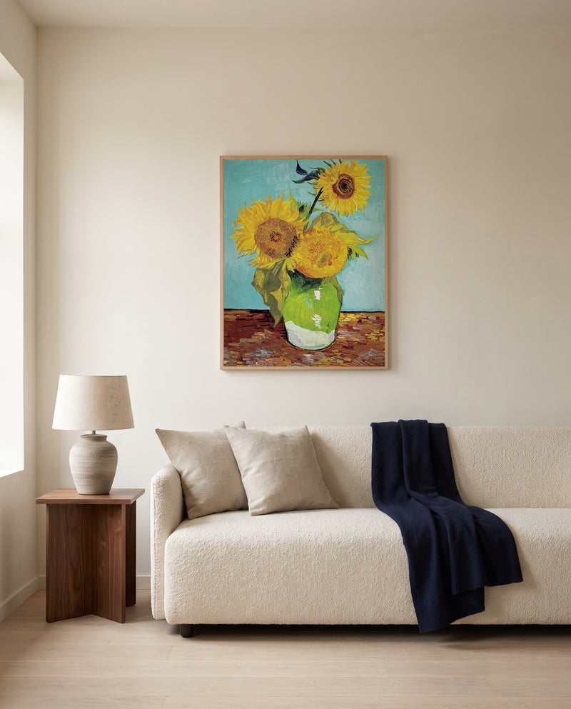 Three Sunflowers in a Vase by Vincent van Gogh framed in natural oak above a cream sofa in a warm living room