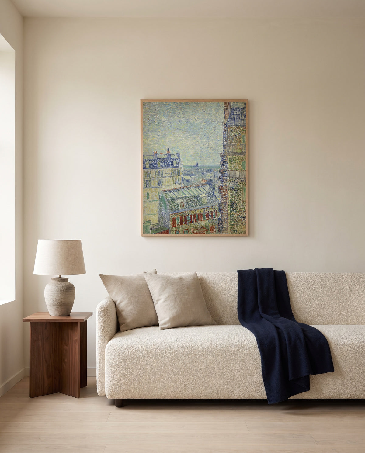 View from Theo’s Apartment by Vincent van Gogh framed in natural oak above a cream sofa in a warm living room