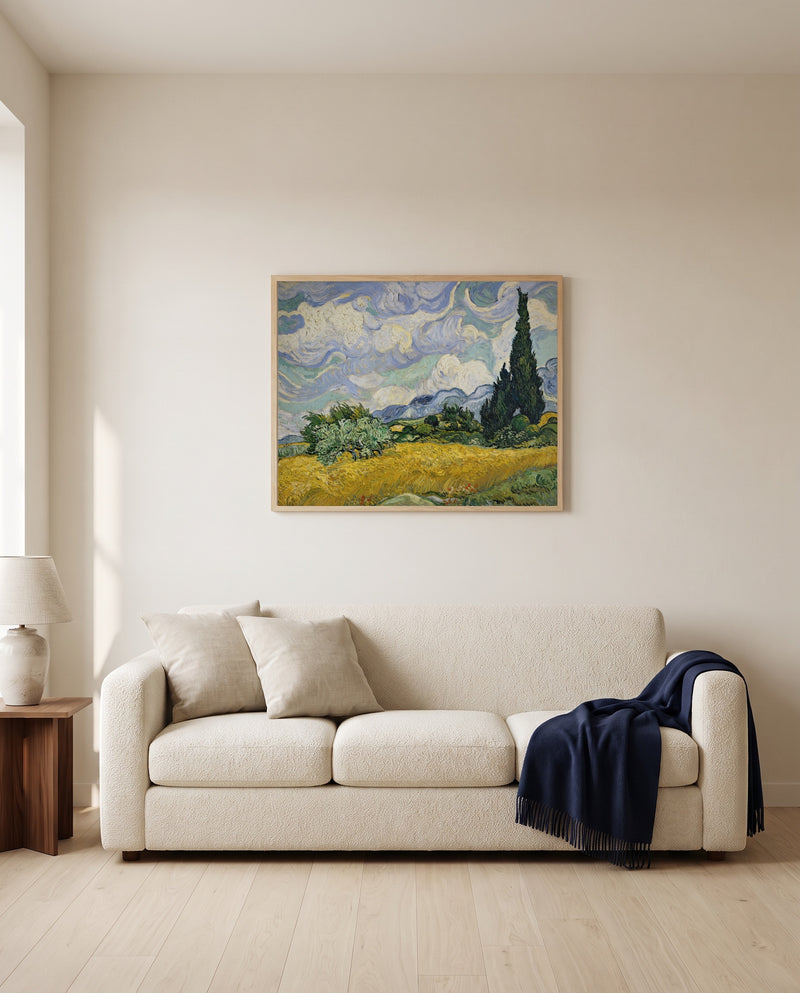 Wheat Field with Cypresses by Vincent van Gogh framed in natural oak above a cream sofa in a warm living room
