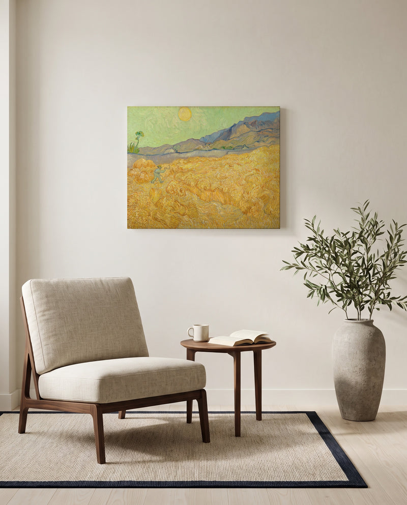 Wheatfield with a Reaper by Vincent van Gogh as a stretched canvas above a linen lounge chair in a reading corner