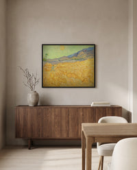 Wheatfield with a Reaper by Vincent van Gogh in a black frame above a walnut sideboard in a dining room