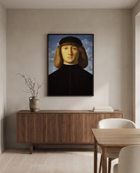 Portrait of a Young Man by Vincenzo Catena in a black frame above a walnut sideboard in a dining room