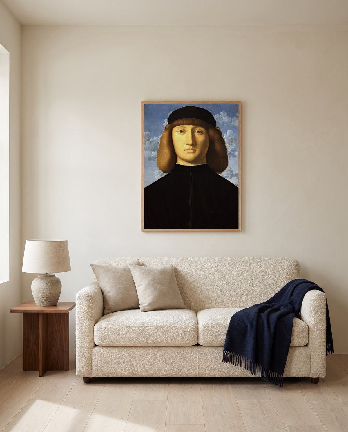 Portrait of a Young Man by Vincenzo Catena framed in natural oak above a cream sofa in a warm living room