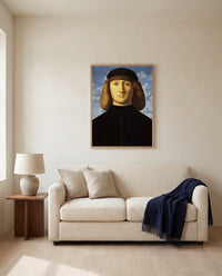 Portrait of a Young Man by Vincenzo Catena framed in natural oak above a cream sofa in a warm living room