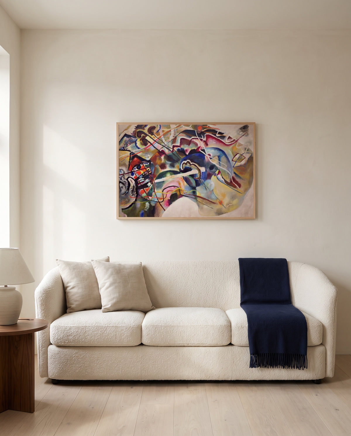 Painting with White Border by Wassily Kandinsky framed in natural oak above a cream sofa in a warm living room