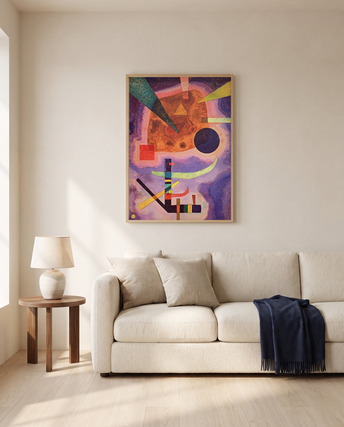 Three Elements by Wassily Kandinsky framed in natural oak above a cream sofa in a warm living room