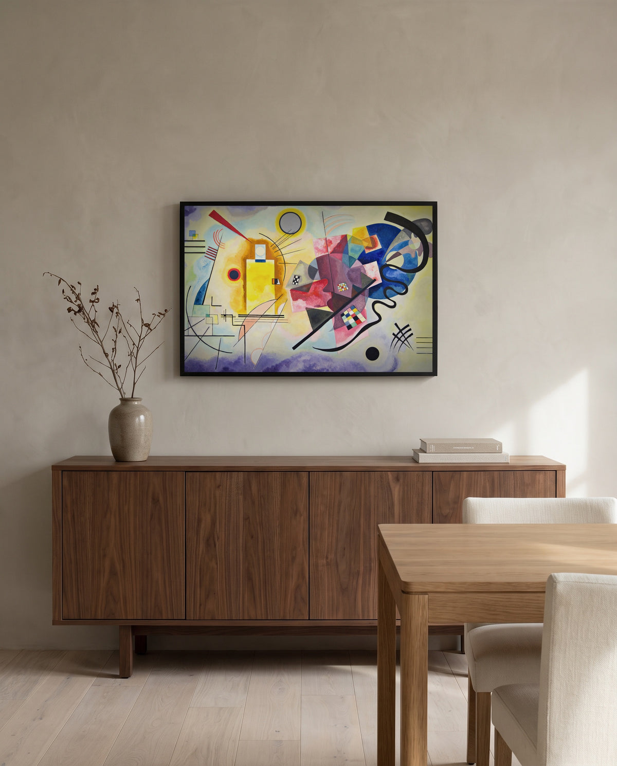 Yellow-Red-Blue by Wassily Kandinsky in a black frame above a walnut sideboard in a dining room