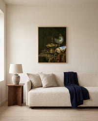 Holbein Bowl and Nautilus Cup by Willem Kalf framed in natural oak above a cream sofa in a warm living room