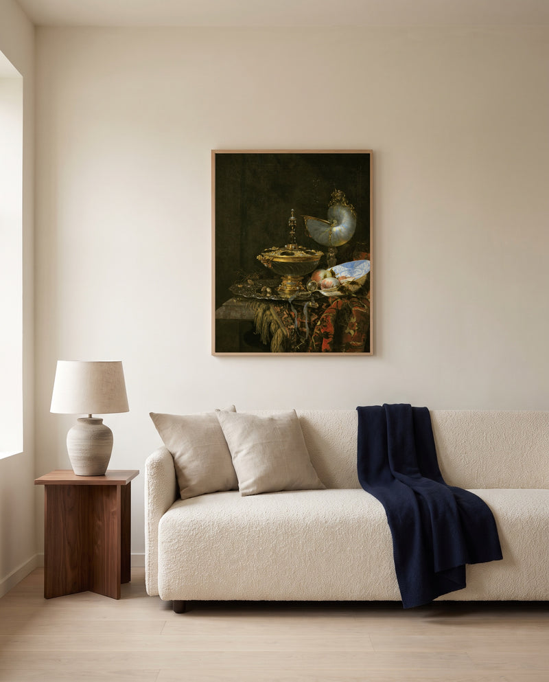 Holbein Bowl and Nautilus Cup by Willem Kalf framed in natural oak above a cream sofa in a warm living room