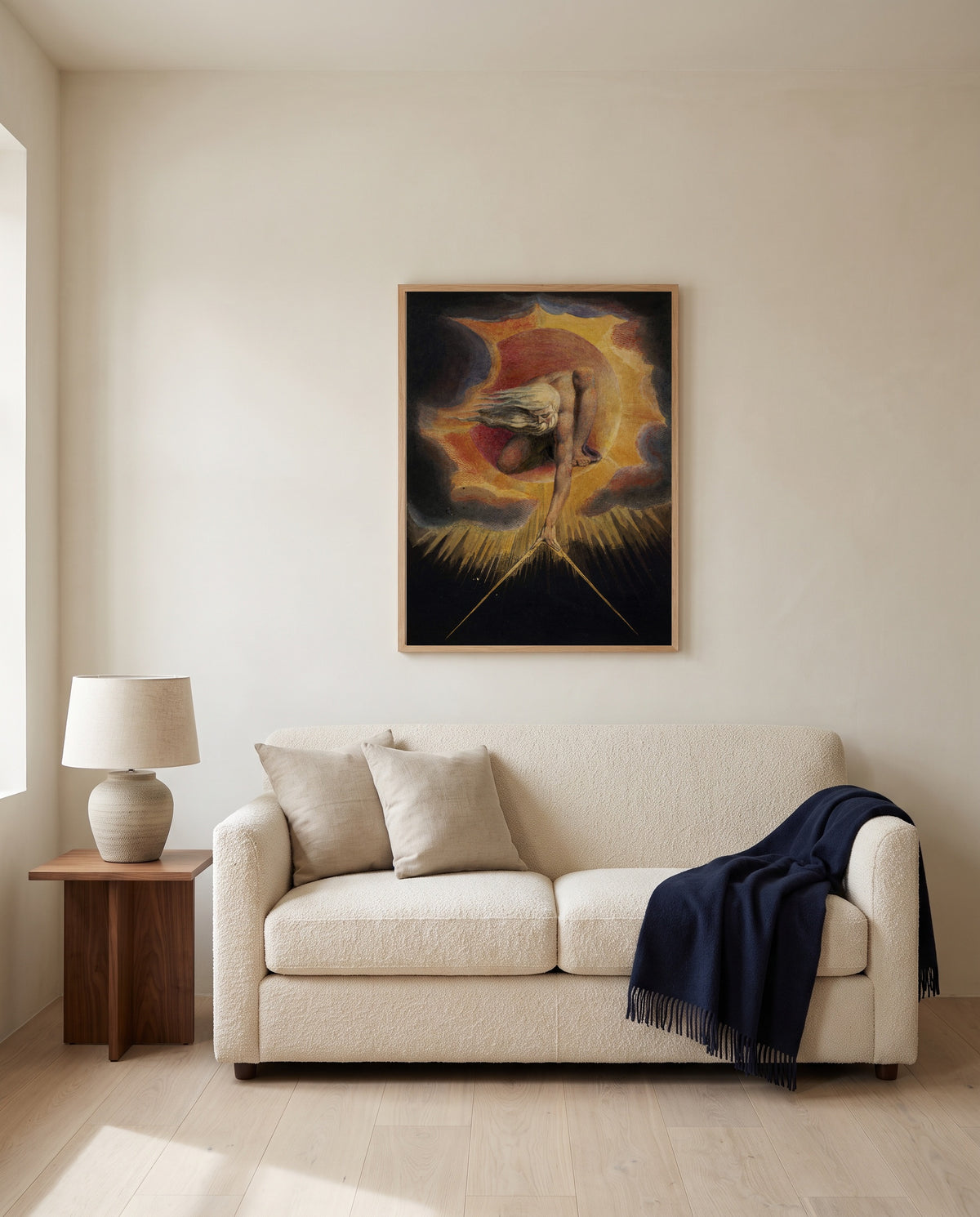 The Ancient of Days by William Blake framed in natural oak above a cream sofa in a warm living room
