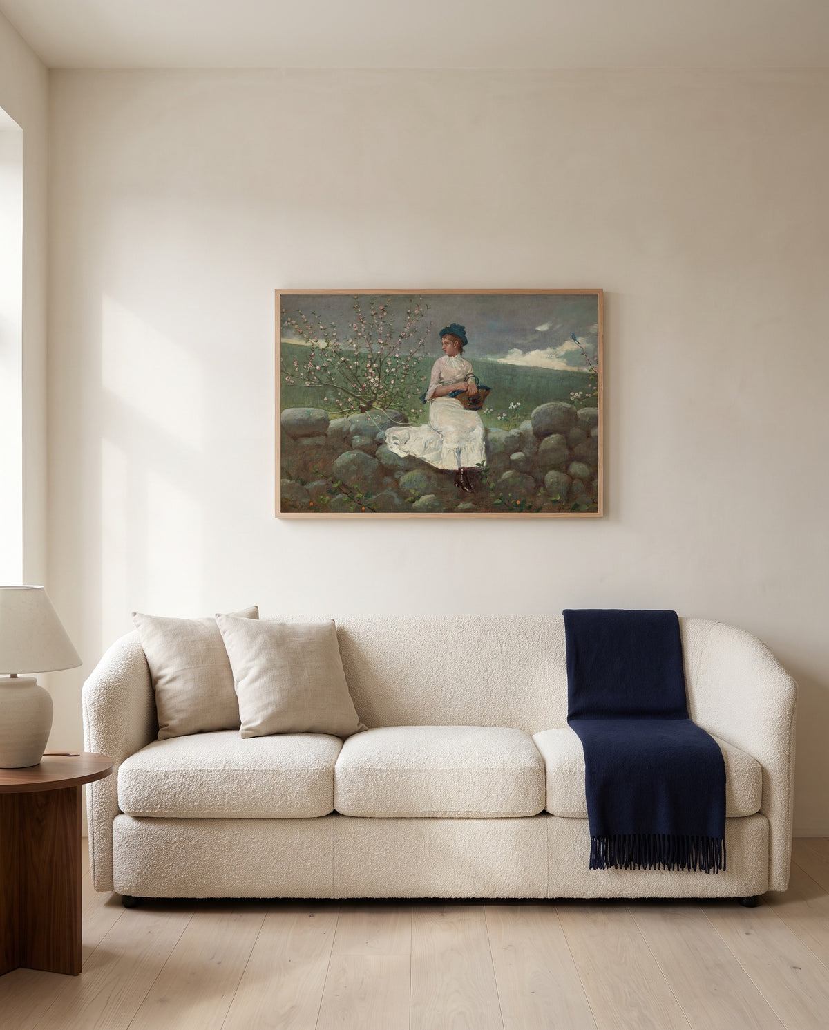 Peach Blossoms by Winslow Homer framed in natural oak above a cream sofa in a warm living room