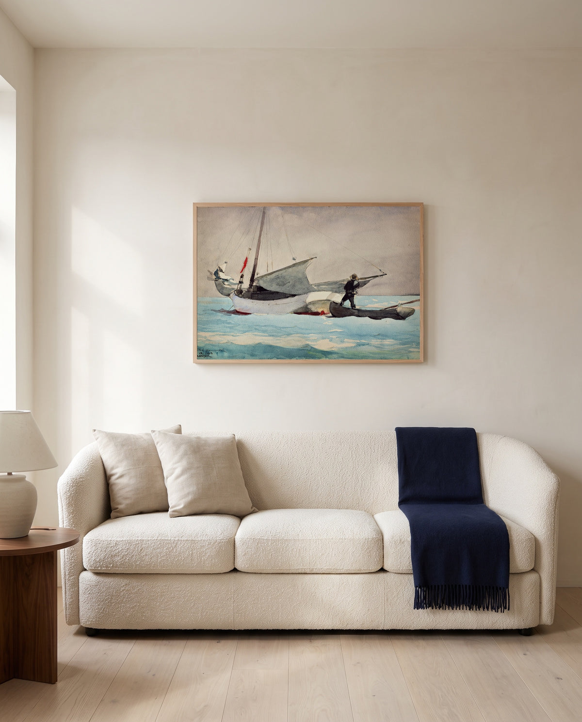 Stowing Sail by Winslow Homer framed in natural oak above a cream sofa in a warm living room