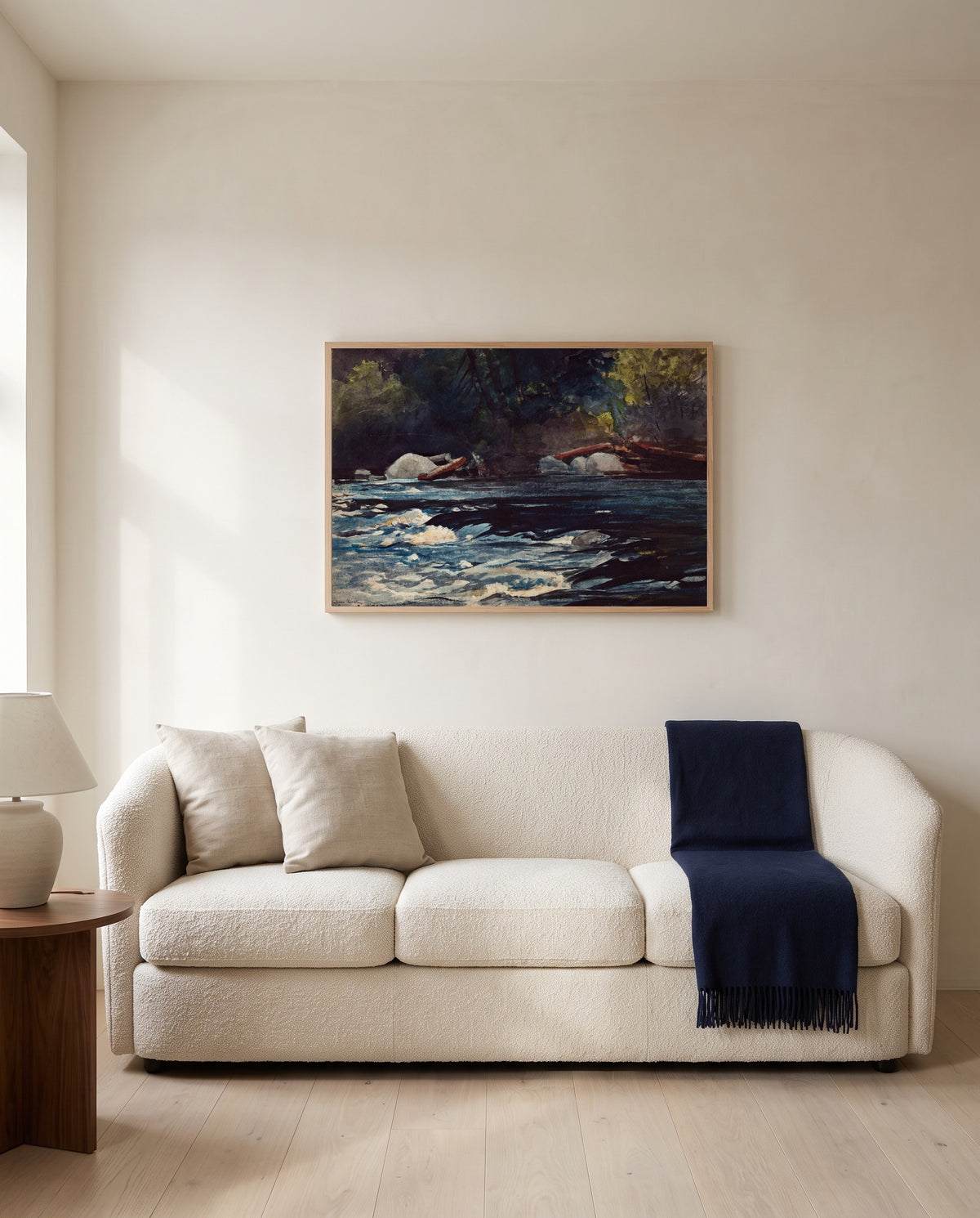 The Rapids, Hudson River by Winslow Homer framed in natural oak above a cream sofa in a warm living room