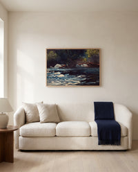The Rapids, Hudson River by Winslow Homer framed in natural oak above a cream sofa in a warm living room